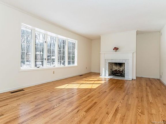 Beautiful southward facing living room with oversized bay window to maximize sunlight streaming into this room. Features to note are the fireplace with marble trim, crown molding around the perimeter of the room and beautiful wood floors,