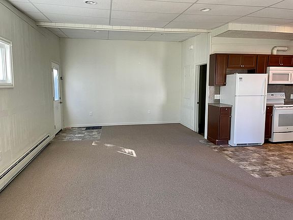 Part of the living area. Front door on the left. Laundry room/closet on the right, behind the kitchen.