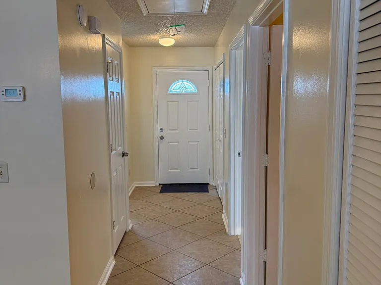 Front main door faces driveway. To the right is the kitchen and to the left is the laundry area. There is a small hallway closet for the mop/bucket, ladder, other cleaning items. The second bathroom and street bedroom located at the hallway.