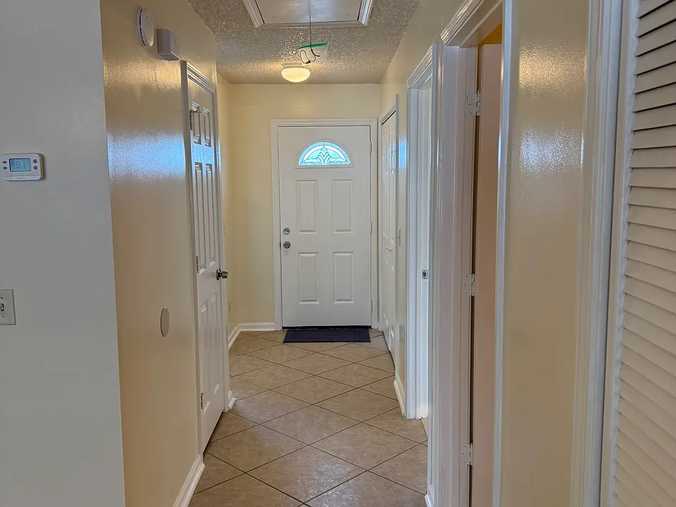 Front main door faces driveway. To the right is the kitchen and to the left is the laundry area. There is a small hallway closet for the mop/bucket, ladder, other cleaning items. The second bathroom and street bedroom located at the hallway.