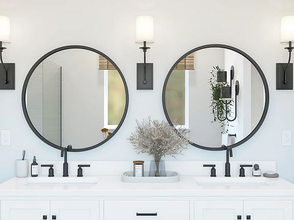 Two black-framed circular mirrors in the primary bath