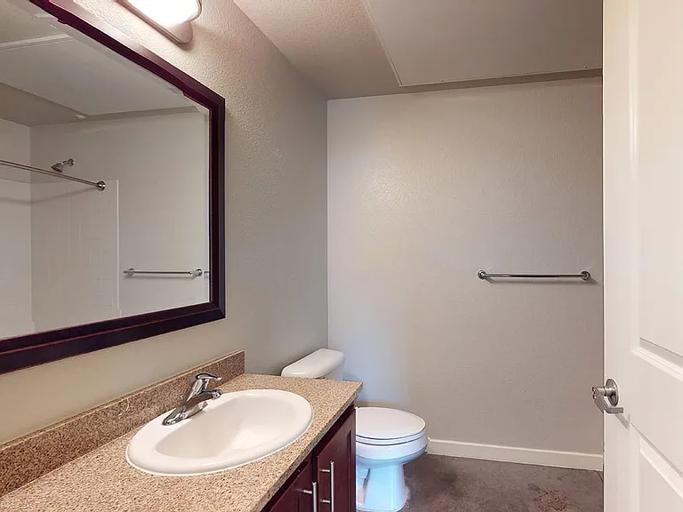 Apartment bathroom with polished concrete flooring.