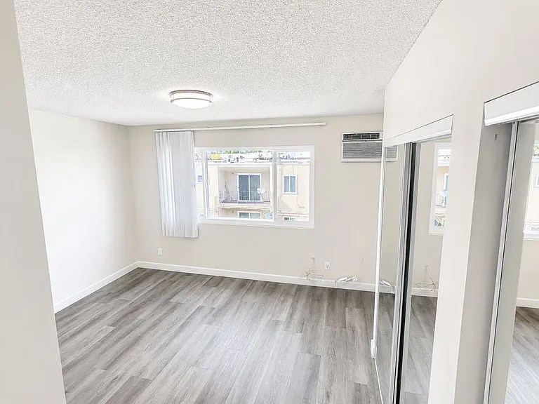 Spacious and sun-filled bedroom overlooking building parking