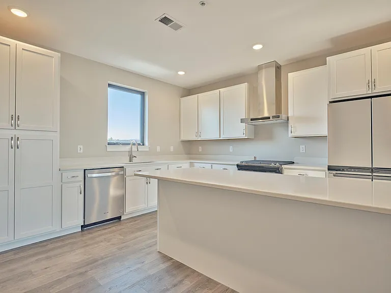 Two pantry cabinets with a large island and quarts counter tops.