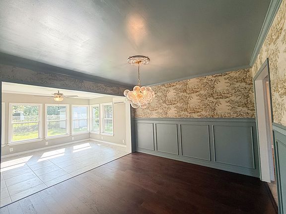 Dining Room
Features wood floors, decorative wainscoting, and a statement chandelier. Opens directly into the sunroom.
