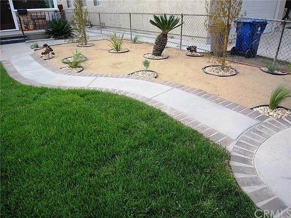 Decorative concrete walkway with brick accents. low maintenance front yard.