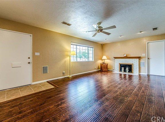 SPACIOUS LIVING ROOM WITH GORGEOUS WOOD FLOORING, CEILING FAN, RECESSED LIGHTING & SMOOTH SCRAPED CEILING OVERHEAD