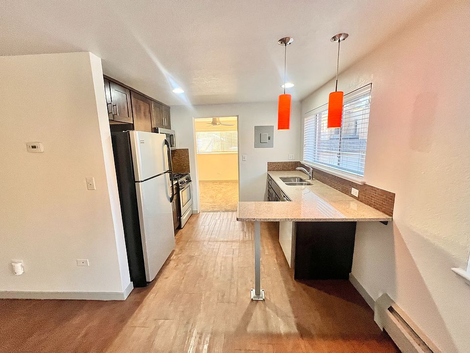 Charming kitchen with modern appliances, elegant granite countertops, and vibrant orange pendant lights.