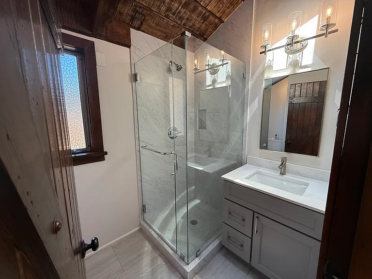 Hallway Bathroom #2 has a shower stall with glass enclosure.