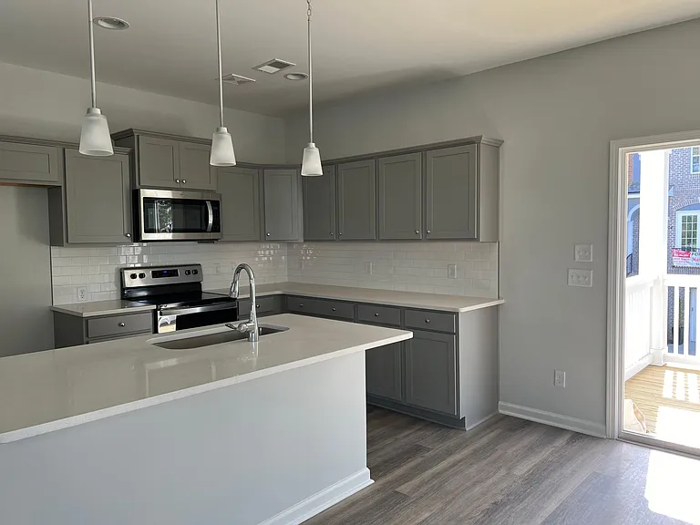 Spacious kitchen with new refrigerator, microwave, and garbage disposal on main level