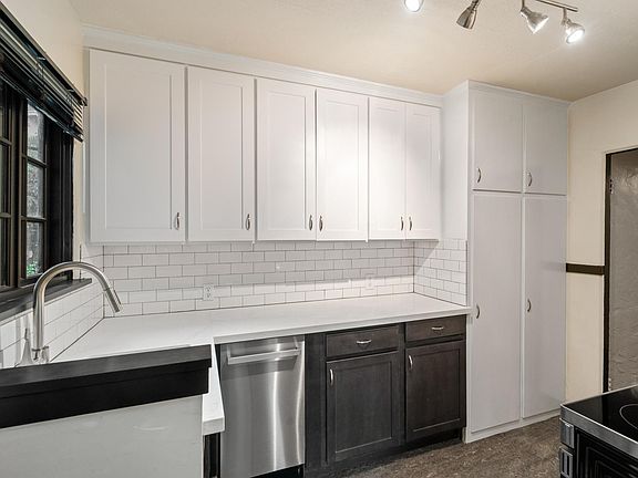 New kitchen with a deep stainless steel sink, dishwasher, stainless steel convection over, overhead microwave.