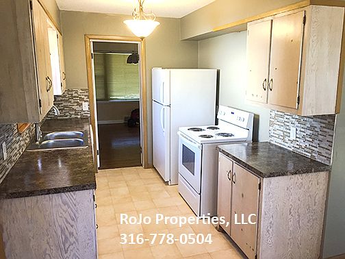 Kitchen has updated countertops, glass tile backsplash, and