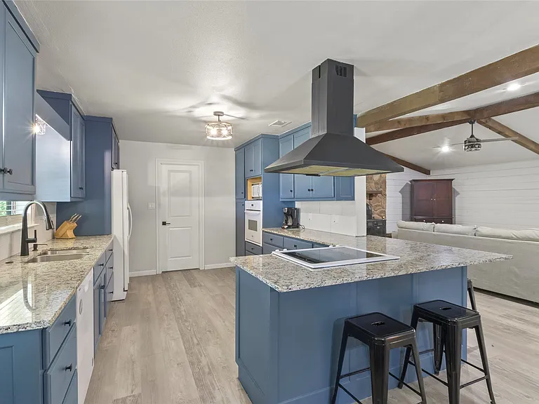 Open-concept kitchen with blue cabinetry and granite countertops