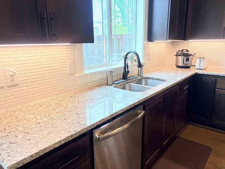 Kitchen sink area with granite countertops.