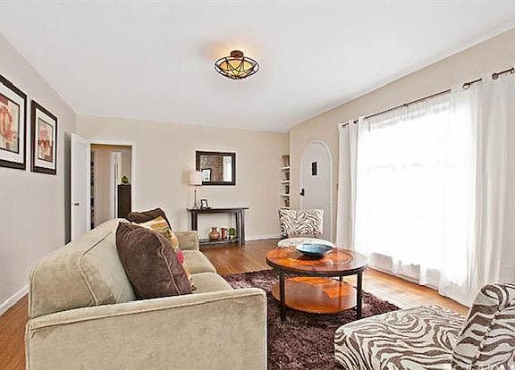 Living Room with view of door to hallway, front door, and built in shelves
