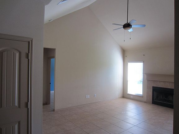 Another view of living room with cathedral ceiling and firep