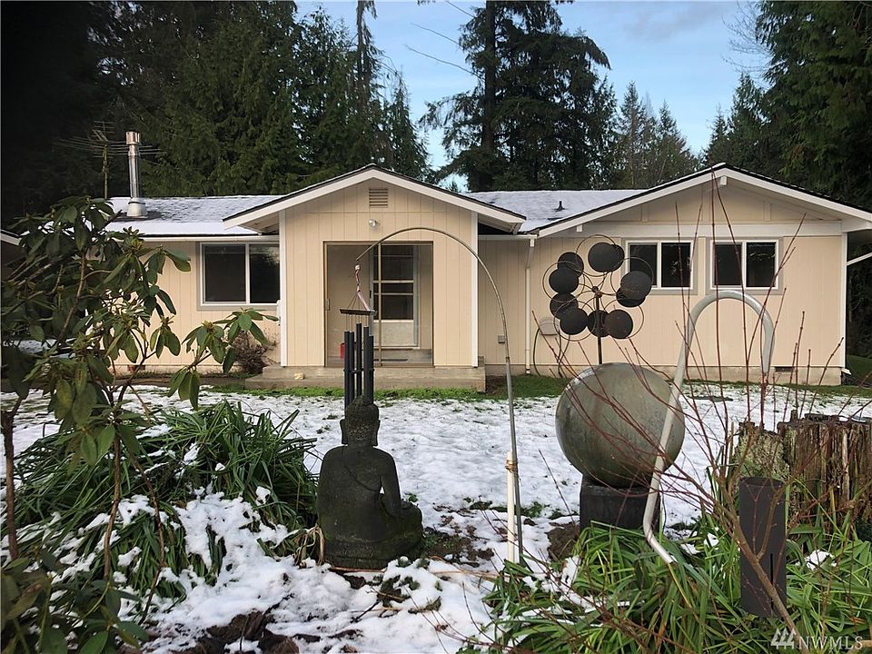 View of the house from the front. Covered front porch. There is a water feature in the garden space between me and the house. 