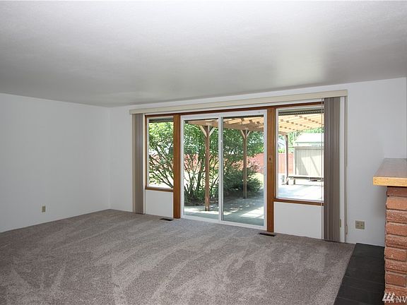 Living room has wood burning fireplace with slate hearth.  Wood floors under carpet in living room as well as the bedrooms.