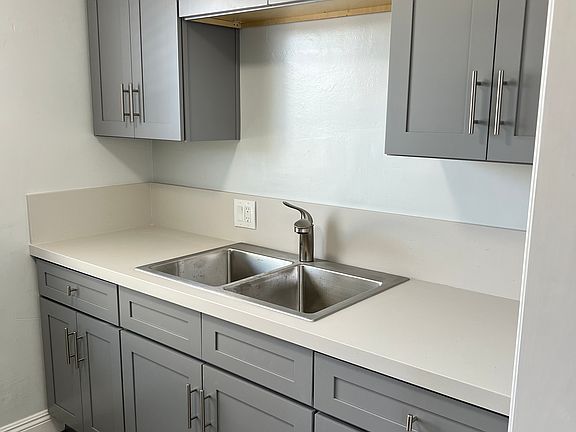 Newly remodeled kitchen with hardwood cabinets, dual sink and vinyl plank flooring.