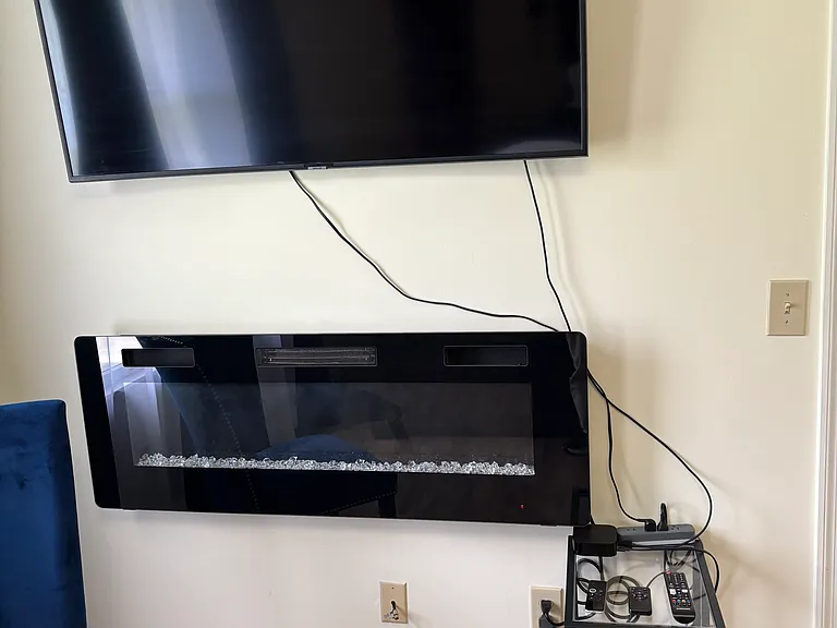 Primary bedroom TV and electric fireplace.