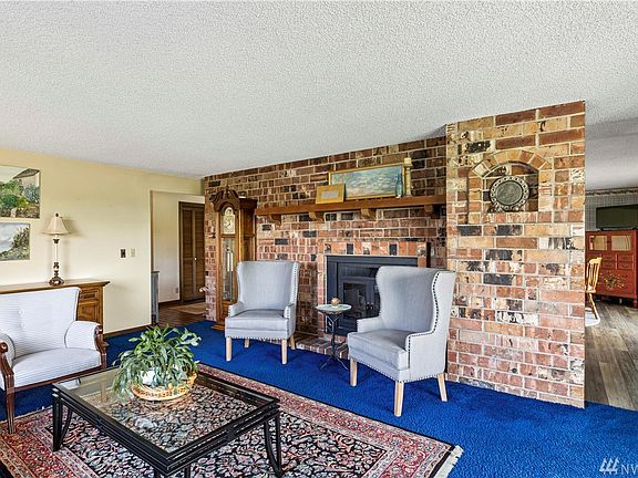 The beautiful brick fireplace is a friendly gathering place in this spacious living room.