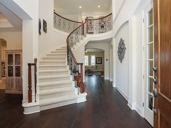 A grand two story foyer greets you upon entry. Elegant staircase with wrought iron spindles adds drama where need most! Note the gleaming hardwoods and light filled space.