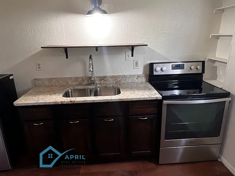 Kitchen with new stainless steel stove, granite counters, ample shelving