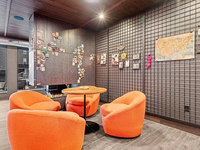Cozy seating in chic furniture near the fireplace of Harley's Residents Only Speakeasy at The Hallon Luxury Apartments in Hopkins MN | apartments near St Louis Park MN