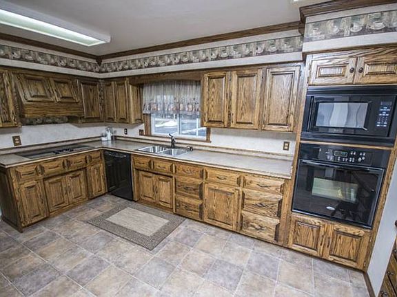 Kitchen (13x15) has built in microwave and matching oven, dishwasher and electric range on counter and inset refrigerator.