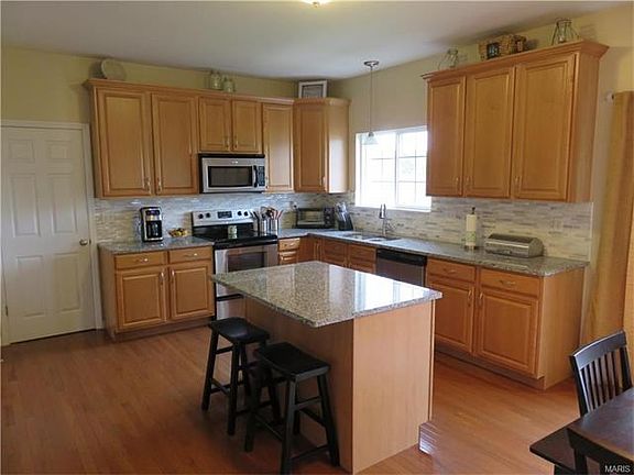 Stylish, upgraded kitchen boasts 42" maple cabinets, brand new granite and tile backsplash, center island/breakfast bar.