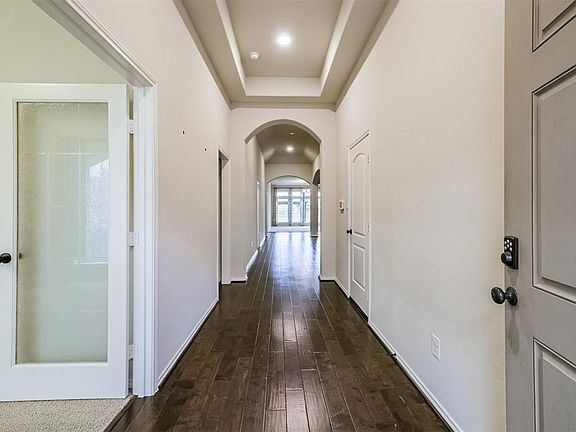 High tray and coffer ceilings as you walk into this welcoming foyer. Dark hardwood engineered floors are the perfect match for these walls and lighting.