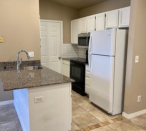 Kitchen includes stainless steel sink, granite countertops, refrigerator, dishwasher, microwave and electric range.