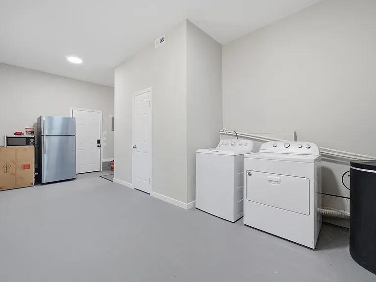 Dedicated laundry/utility area with full-size washer and dryer, plus extra space for storage and household essentials.