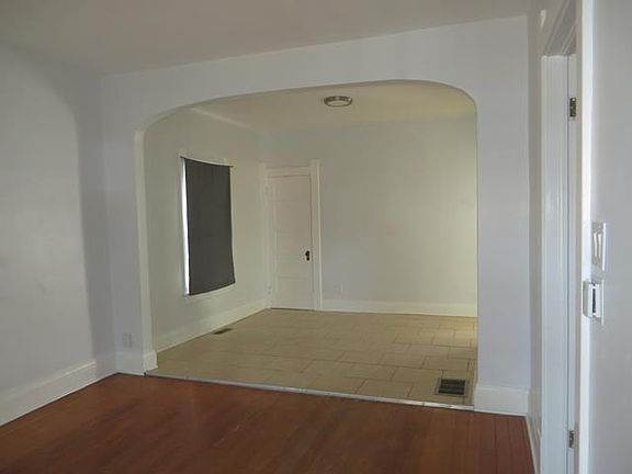 Living and dining areas with storage closet above stairs.
