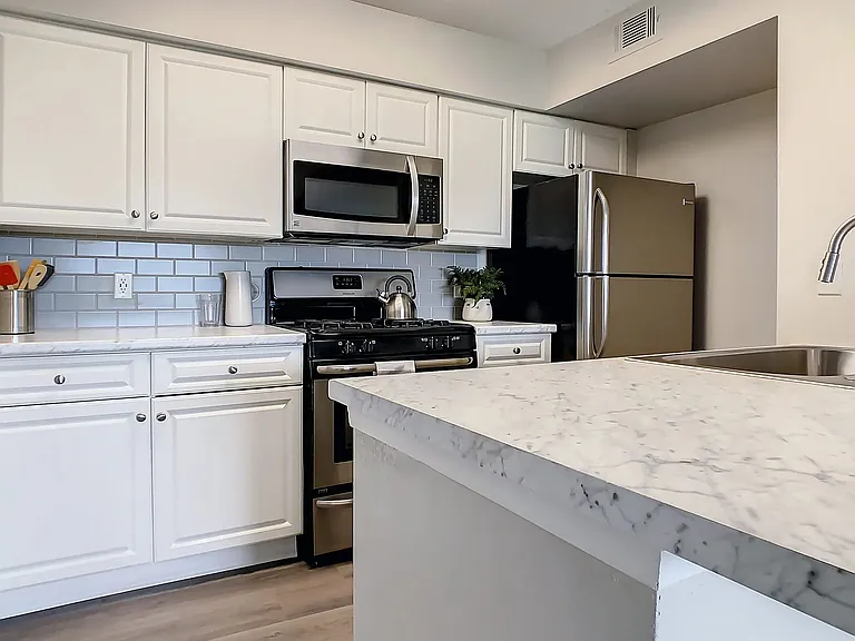 Swoon over our newly remodeled kitchen with its pristine white cabinets, gray subway tile backsplash, and white Carrara countertops, all complemented by stainless steel appliances.