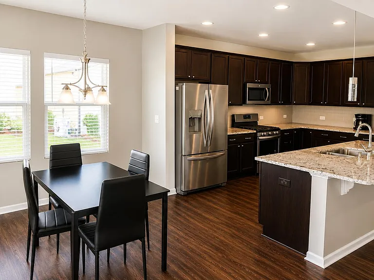 Open-concept kitchen with large island, stainless appliances, and nearby dining area for easy everyday meals.