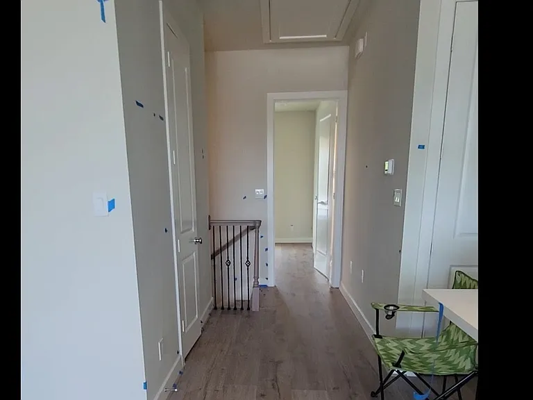 hallway leads to stairs, half bathroom and main bedroom