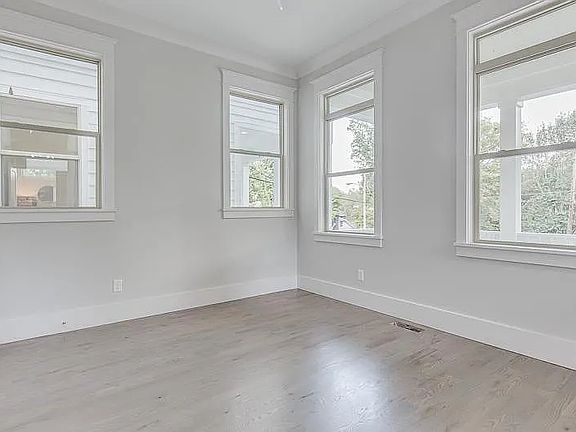 downstairs bedroom with windows out to the front porch