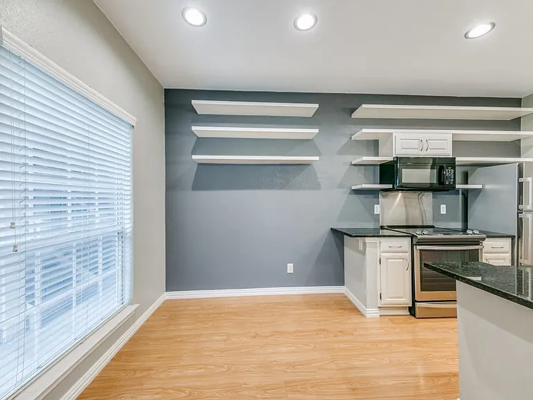 Kitchen featuring light hardwood / wood-style flooring, plenty of natural light, stainless steel electric range oven, fridge w icemaker, and white cabinets.