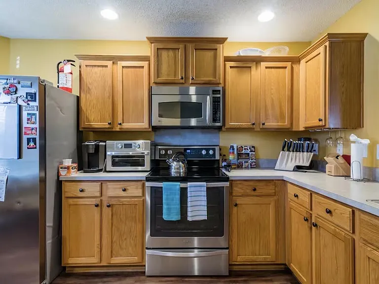 U-shaped kitchen with ample wood cabinetry, stainless appliances, and generous counter space for daily meal prep.
