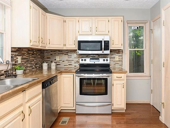 Kitchen with stainless steel appliances, electric range, dishwasher, microwave, and full size washer and dryer in the closet behind on of the doors.