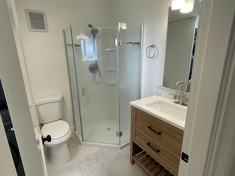 2nd bath with walk in shower. Custom vanity with undermount sink and marble backsplash