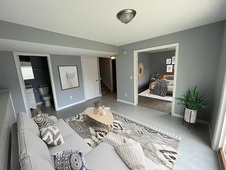 Open area in the lower level of the home. Bathroom is on the left, closet is behind the door, bedroom/den/office area is to the right.