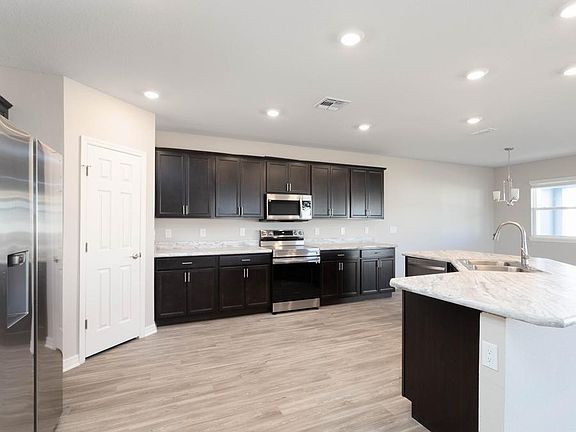 Your new kitchen includes a large island, Samsung appliances, and 36-in. cabinets with crown molding