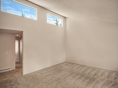 Living roomw with vaulted cielings and picture windows