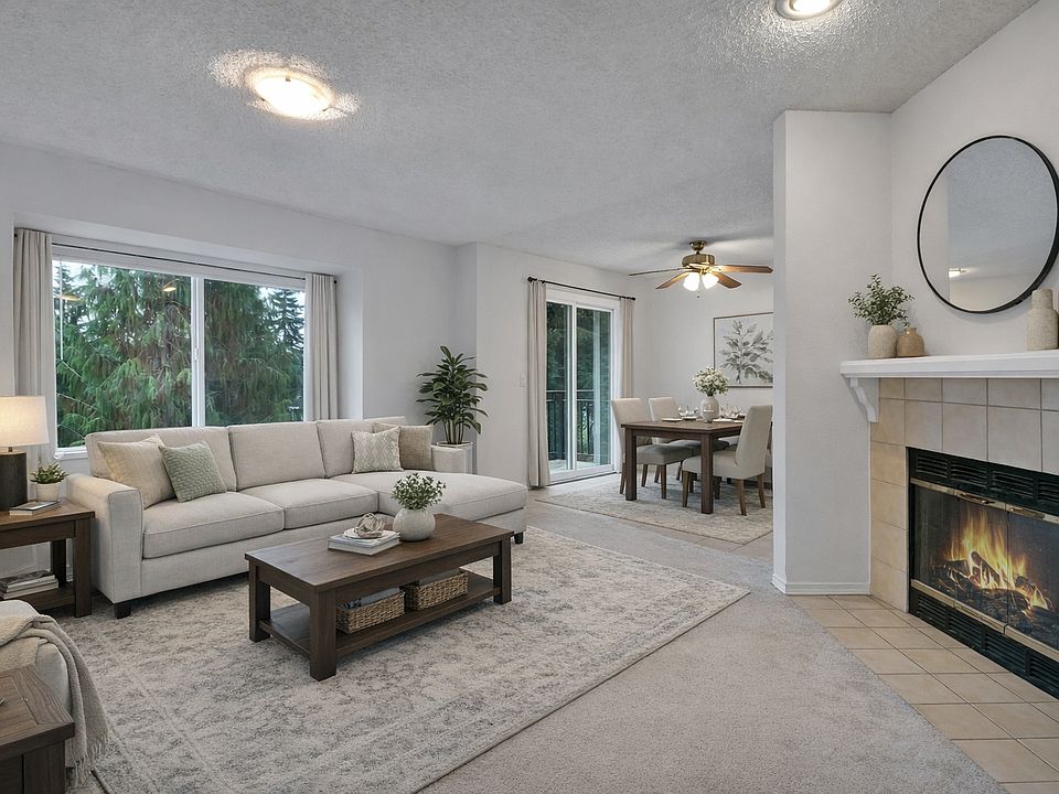 Bright, open living room with cozy fireplace, large windows, and an easy flow into the dining area_ideal for relaxing or entertaining.