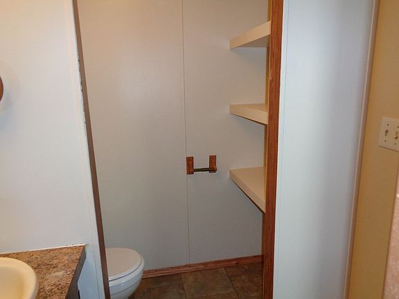 Toilet and storage shelves in Master Bathroom