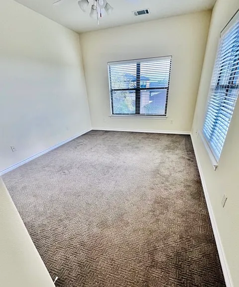 Huge secondary bedroom located upstairs with plush carpet, large windows overlooking the city of Lakeway and providing plenty of natural light