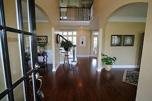 Double-door entrance with dark mahogany flooring and soaring ceilings
