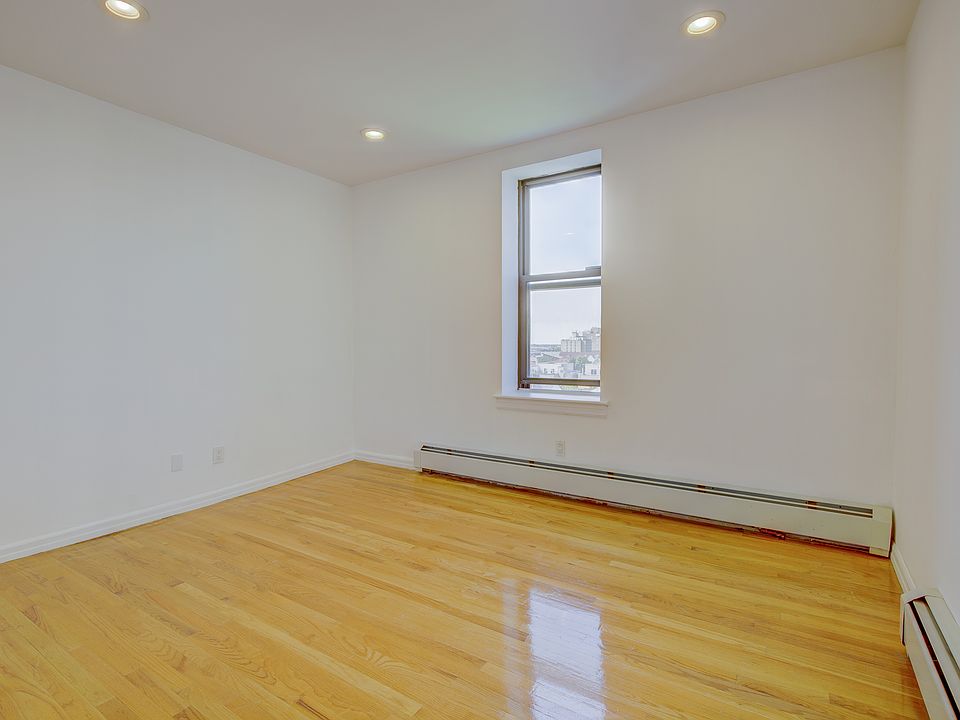 Spare room featuring baseboard heating, wood finished floors, and recessed lighting